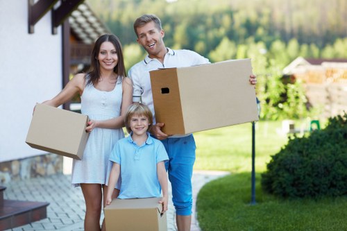 Removal team transporting boxes and furniture on moving day